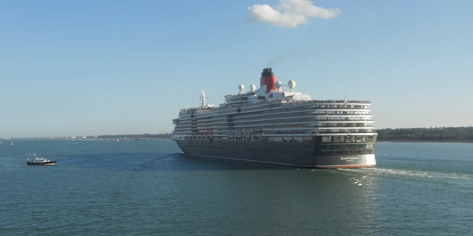 Cunard's Queen Victoria sailing along Southampton Water under a clear blue sky