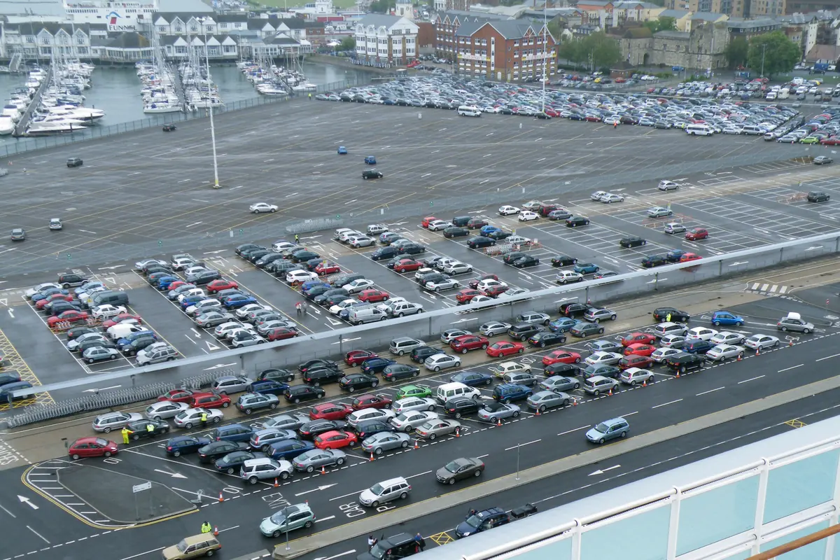 Rows of parked cars in the port car park beside Ocean Terminal, seen from a ship